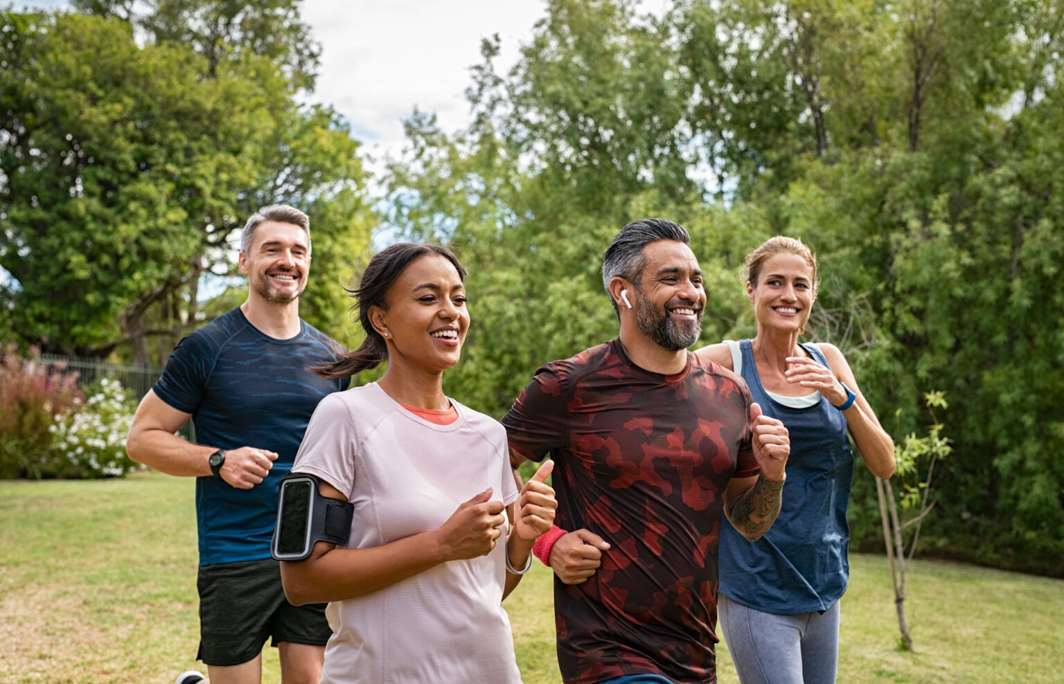 4 Adult athletes(2 men and 2 women) above 40 running in a park.