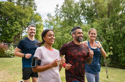 4 Adult athletes(2 men and 2 women) above 40 running in a park.