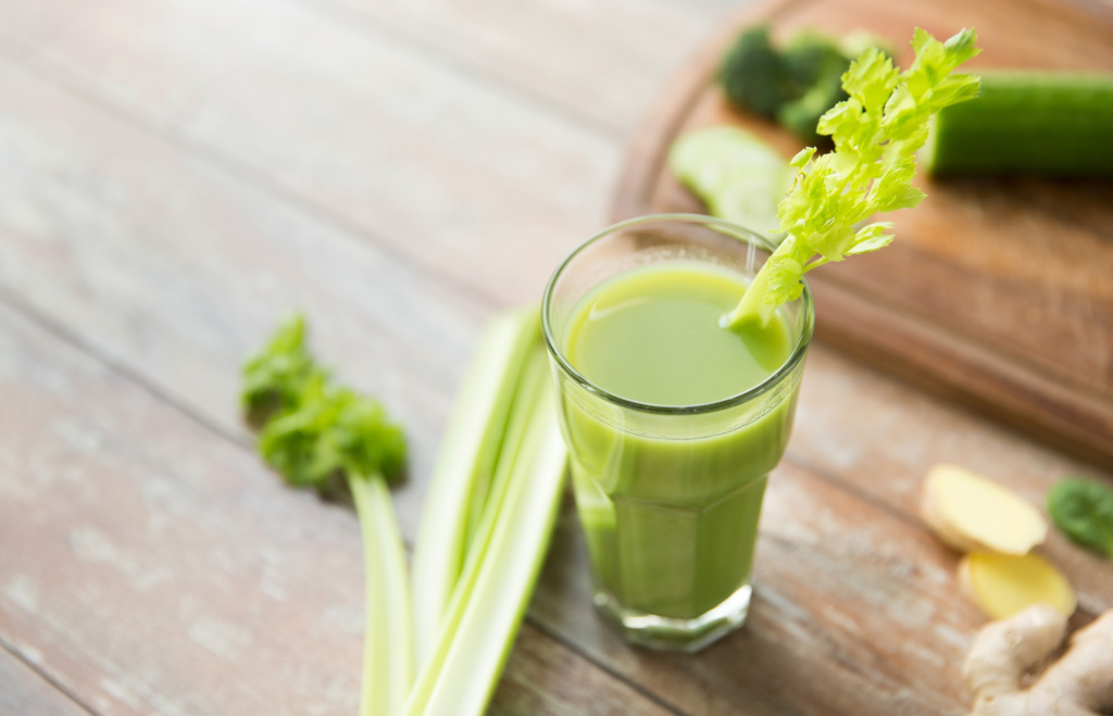 Celery juice in a glass on a wooden table